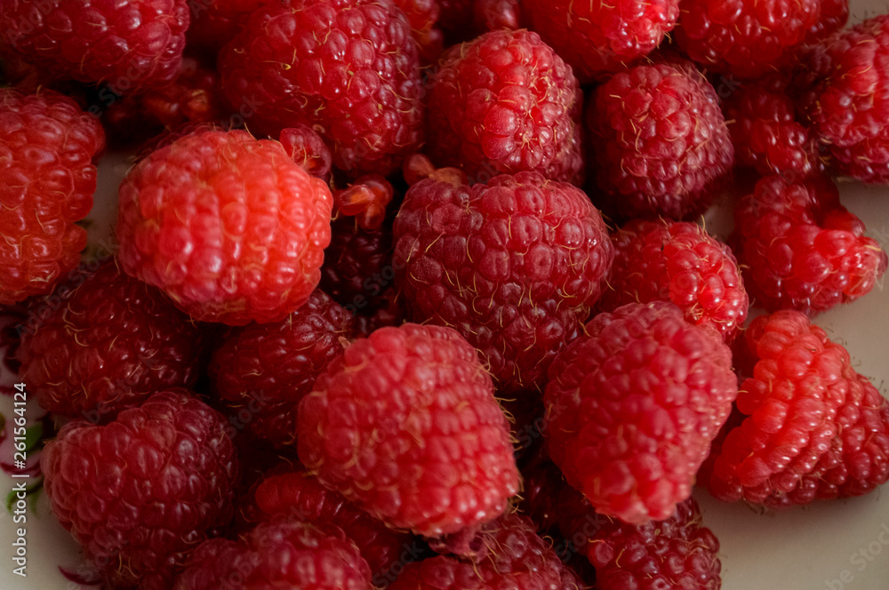Big ripe raspberries are laying on the table covered with white tablecloth Big ripe raspberries are laying on the table covered with white tablecloth
