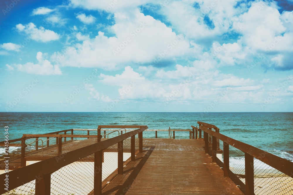 background photo of sandy beach, wooden deck and ocean waves