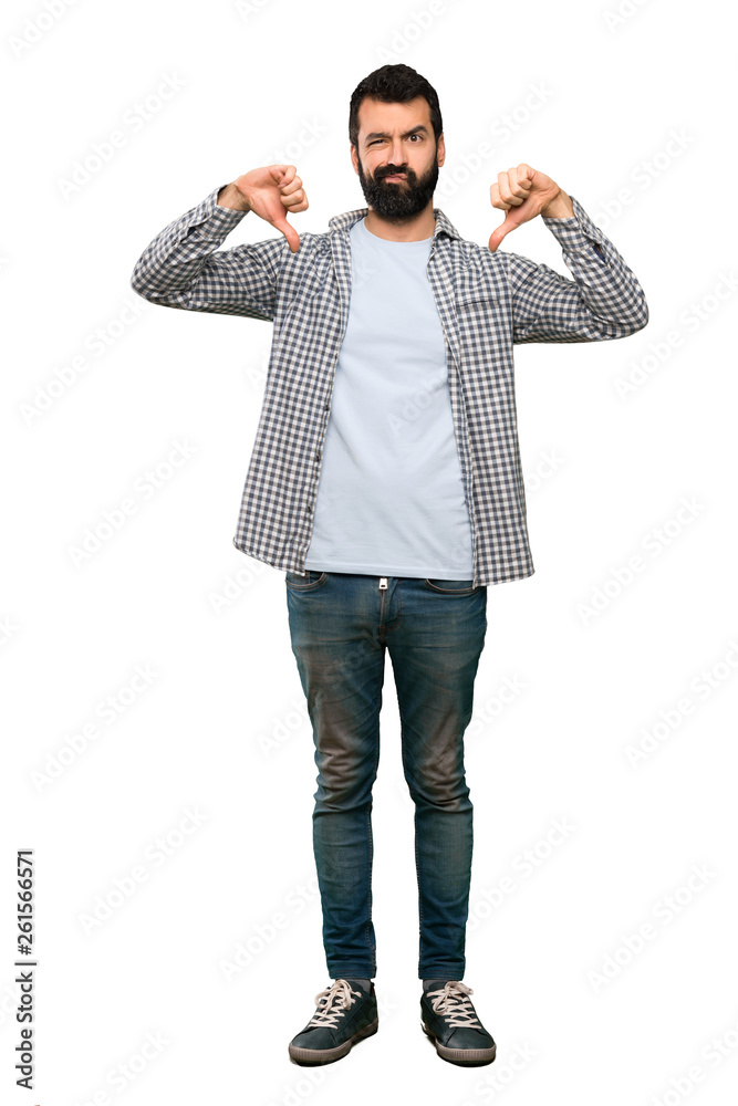 Handsome man with beard showing thumb down over isolated white background Handsome man with beard showing thumb down over isolated white background