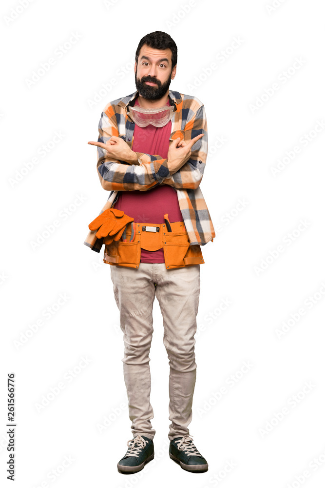 Craftsmen man pointing to the laterals having doubts over isolated white background Craftsmen man pointing to the laterals having doubts over isolated white background