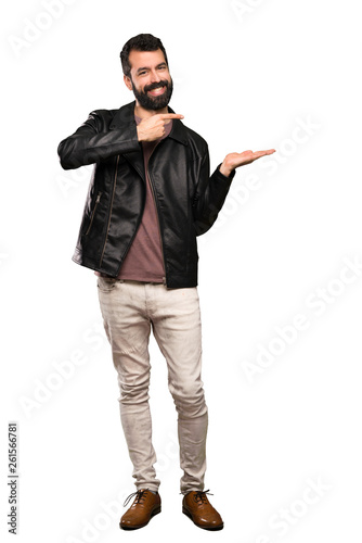 Handsome man with beard holding copyspace imaginary on the palm to insert an ad over isolated white background