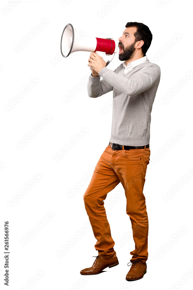 Handsome man shouting through a megaphone over isolated white background Handsome man shouting through a megaphone over isolated white background