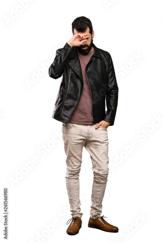 Handsome man with beard with tired and sick expression over isolated white background