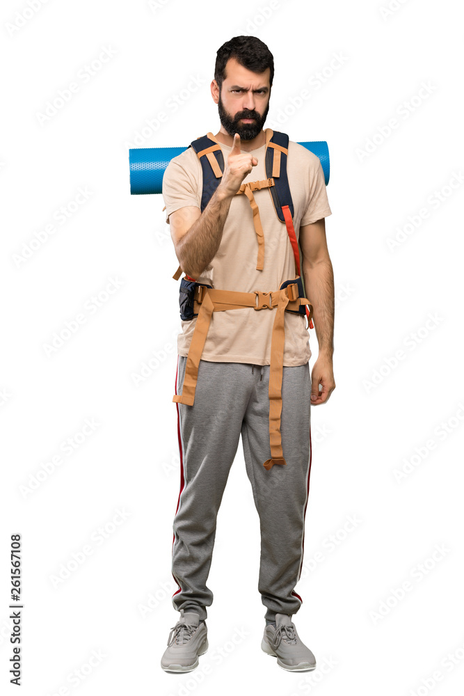 Hiker man frustrated and pointing to the front over isolated white background