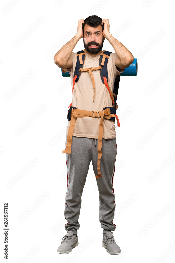 Hiker man frustrated and takes hands on head over isolated white background Hiker man frustrated and takes hands on head over isolated white background