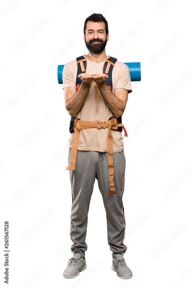 Hiker man holding copyspace imaginary on the palm to insert an ad over isolated white background Hiker man holding copyspace imaginary on the palm to insert an ad over isolated white background