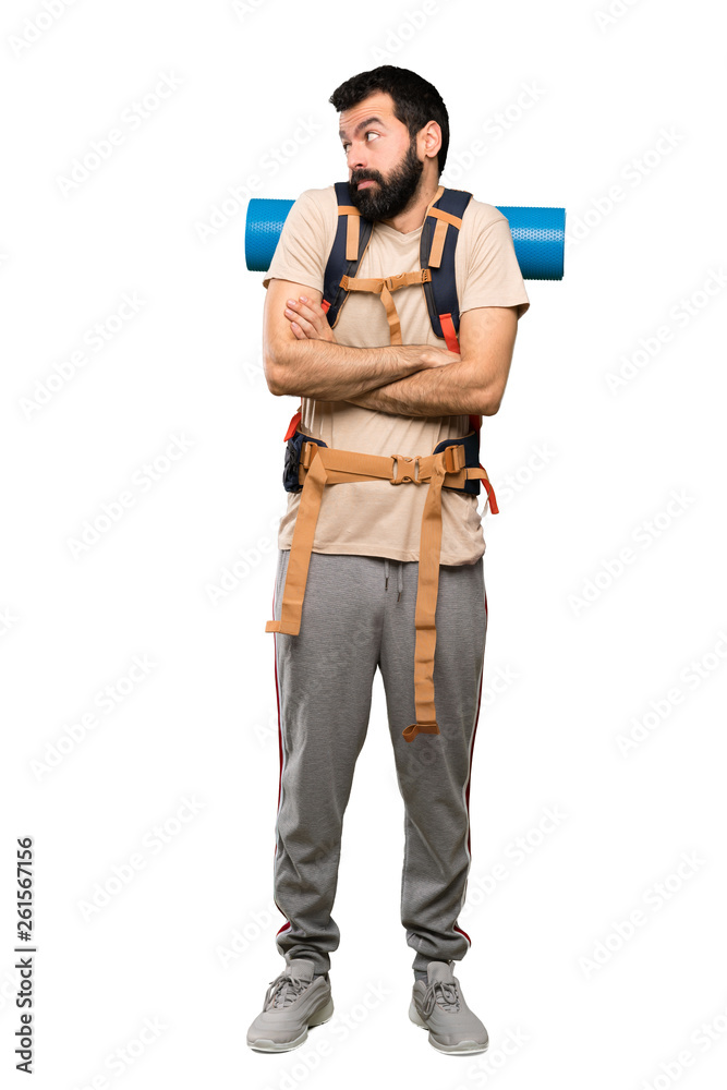 Hiker man making doubts gesture while lifting the shoulders over isolated white background Hiker man making doubts gesture while lifting the shoulders over isolated white background