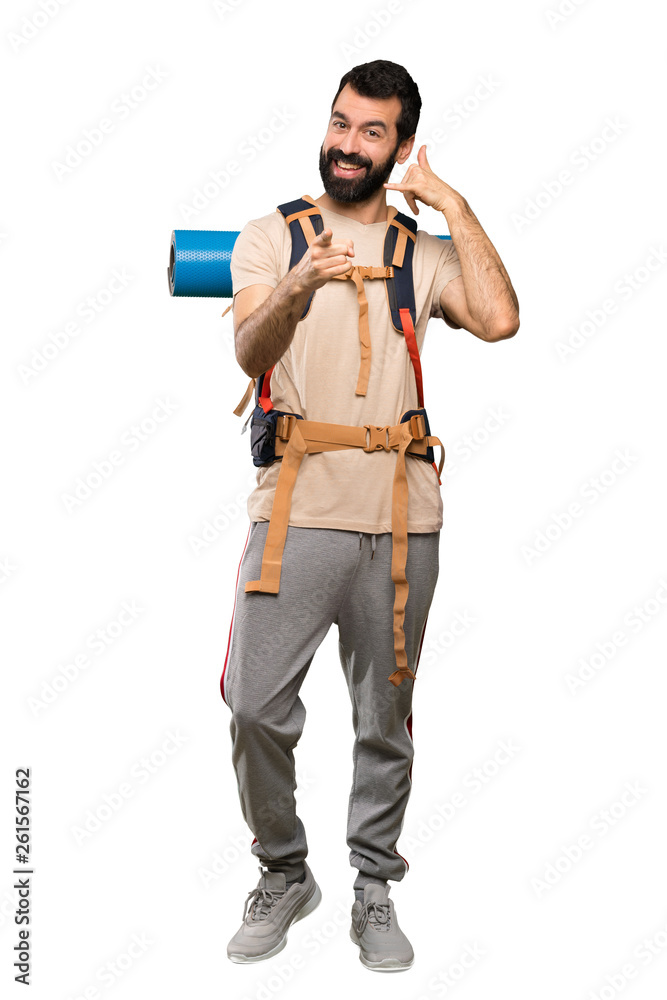 Hiker man making phone gesture and pointing front over isolated white background Hiker man making phone gesture and pointing front over isolated white background