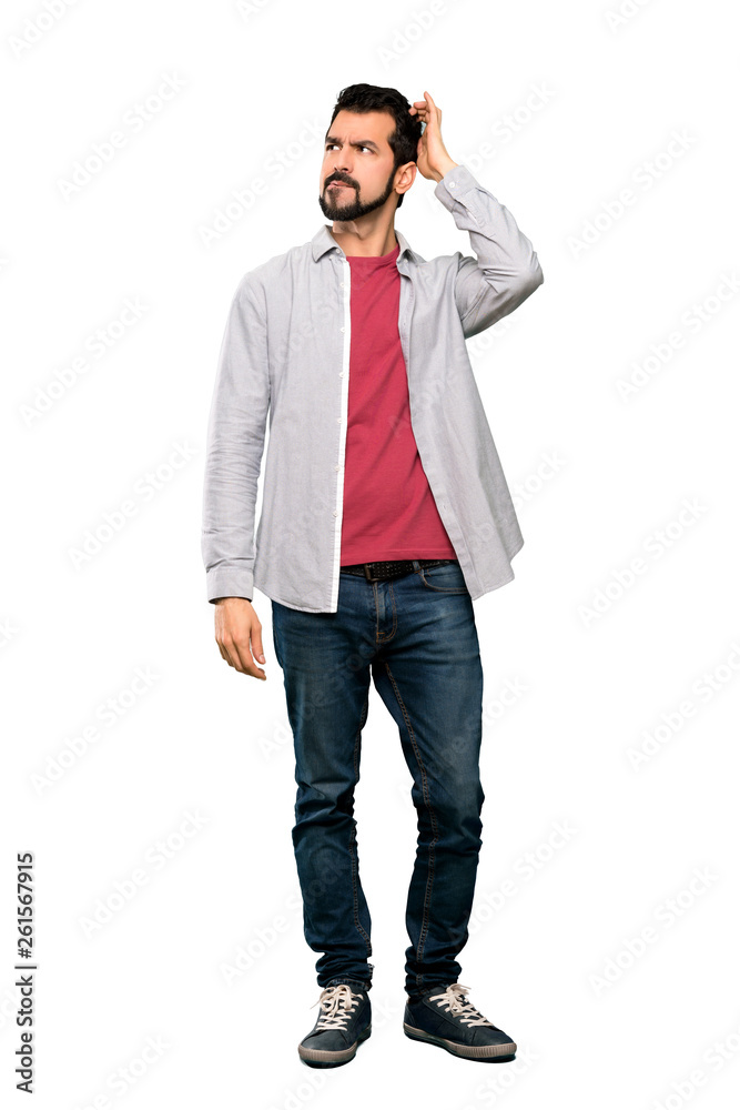Full-length shot of Handsome man with beard having doubts while scratching head over isolated white background Full-length shot of Handsome man with beard having doubts while scratching head over isolated white background