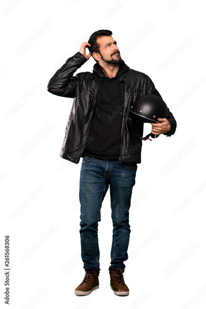 Full-length shot of Biker man having doubts while scratching head over isolated white background Full-length shot of Biker man having doubts while scratching head over isolated white background