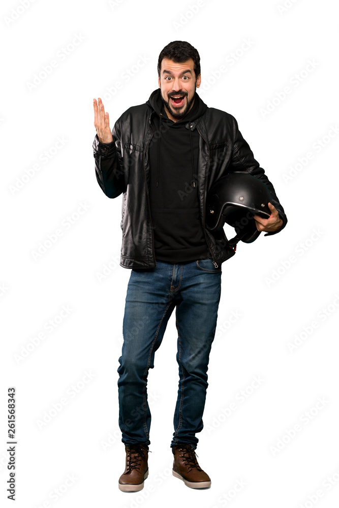 Full-length shot of Biker man with shocked facial expression over isolated white background Full-length shot of Biker man with shocked facial expression over isolated white background