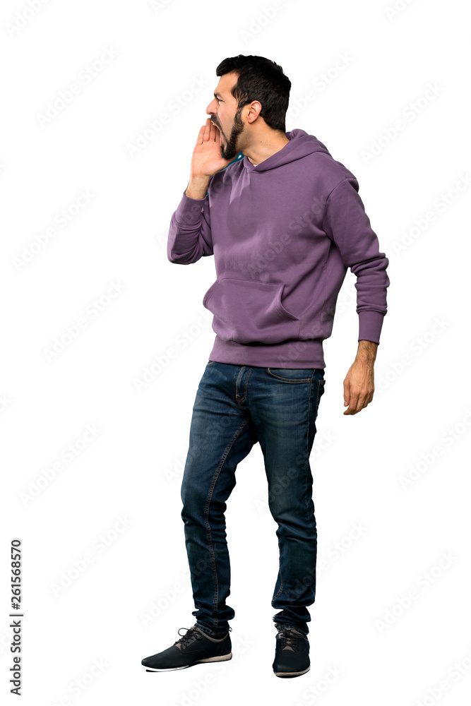 Full-length shot of Handsome man with sweatshirt shouting with mouth wide open to the lateral over isolated white background Full-length shot of Handsome man with sweatshirt shouting with mouth wide open to the lateral over isolated white background
