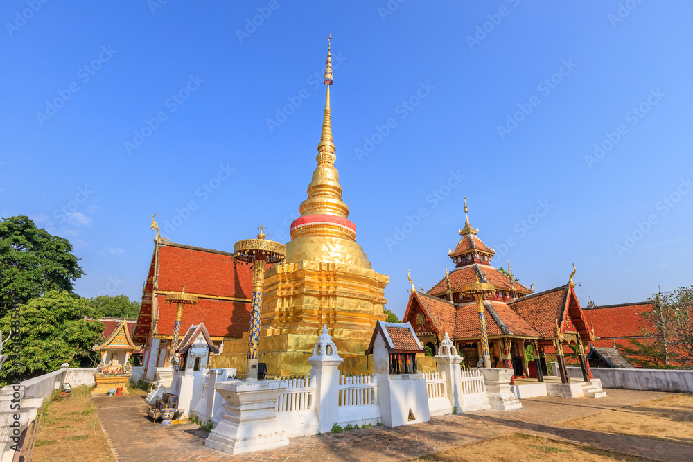 Fototapeta premium Golden pagoda and Buddha pavilion at Wat Pong Sanuk temple and museum in Lampang, North of Thailand