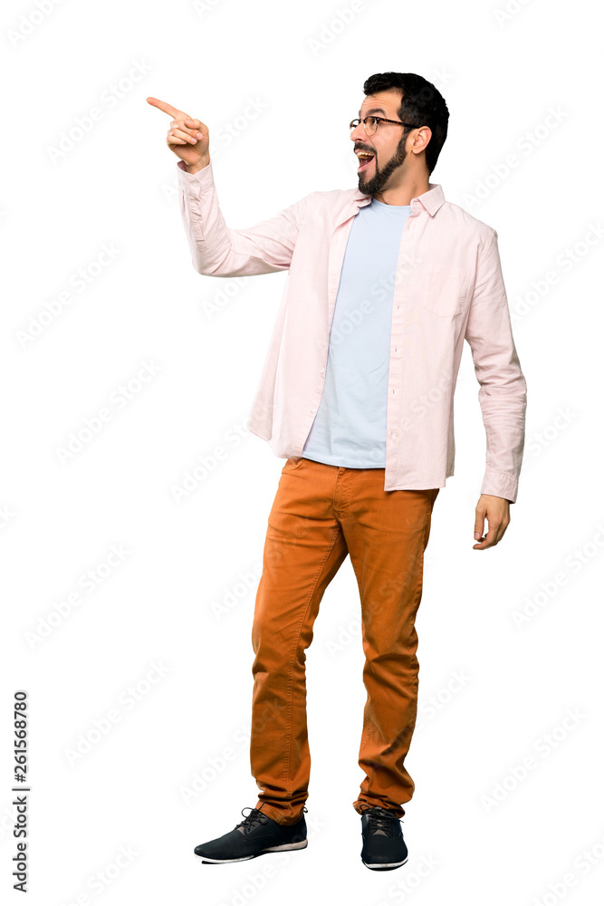 Fototapeta premium Full-length shot of Handsome man with beard pointing away over isolated white background