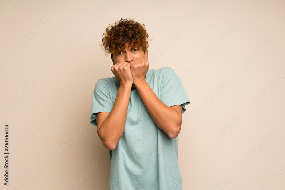 African american man with green shirt nervous and scared putting hands to mouth African american man with green shirt nervous and scared putting hands to mouth