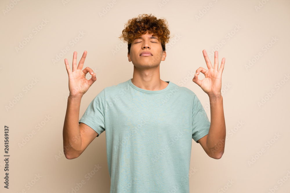 African american man with green shirt in zen pose African american man with green shirt in zen pose