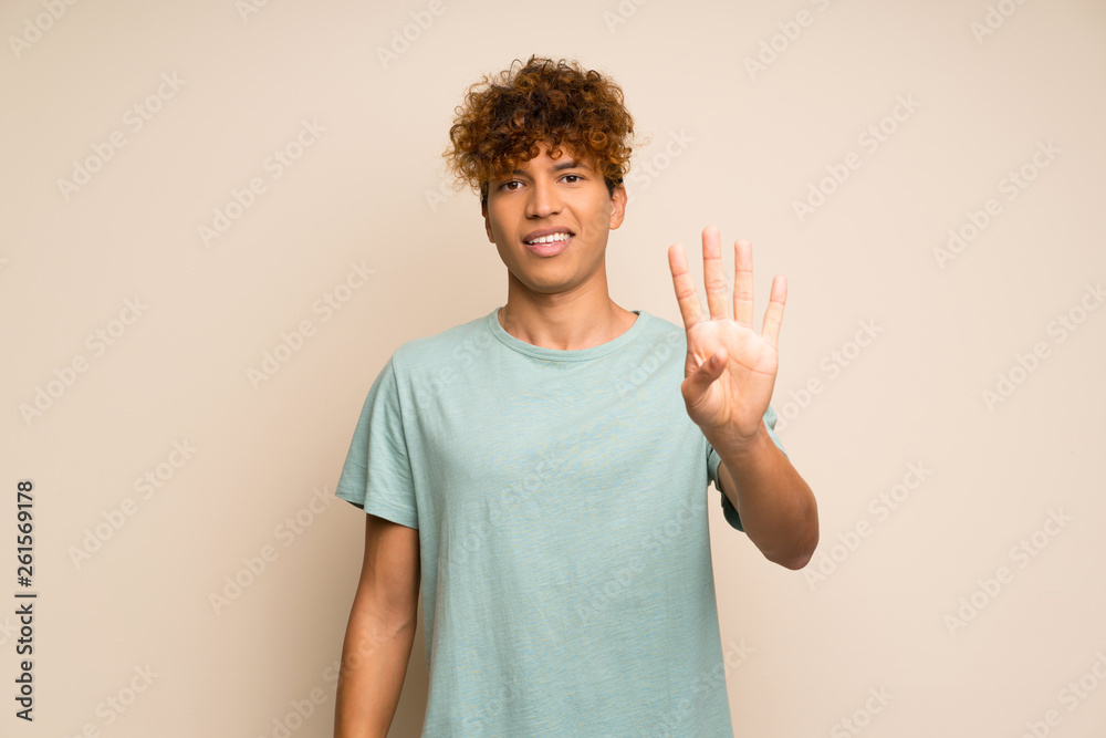 African american man with green shirt happy and counting four with fingers