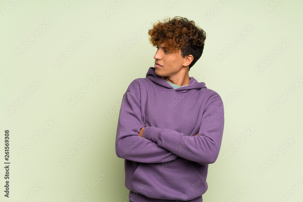 Young african american man over isolated green wall portrait Young african american man over isolated green wall portrait