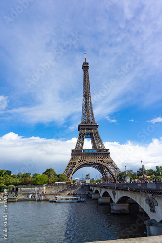 Eiffel Tower with view of Seine river and the bridge in cloudy blue sky day in Paris  France