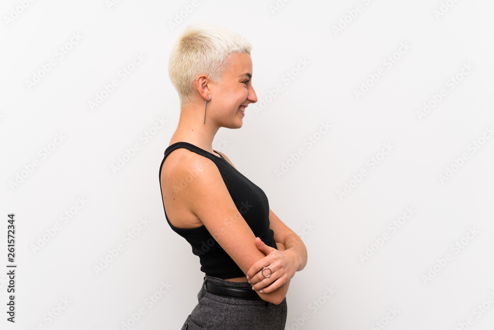 Teenager girl with short hair over white wall in lateral position Teenager girl with short hair over white wall in lateral position