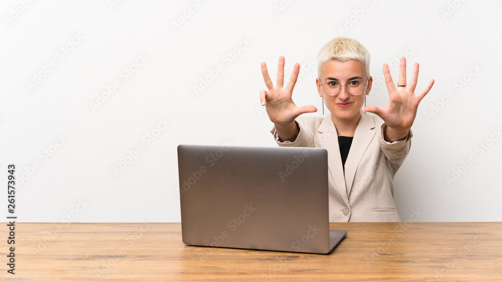 Teenager girl with short hair with a laptop counting nine with fingers Teenager girl with short hair with a laptop counting nine with fingers