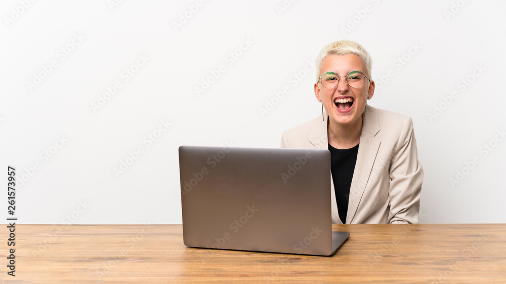 Teenager girl with short hair with a laptop shouting to the front with mouth wide open Teenager girl with short hair with a laptop shouting to the front with mouth wide open