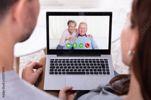 Couple Video Conferencing With Their Parents On Laptop