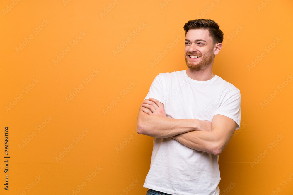 Redhead man over brown wall happy and smiling