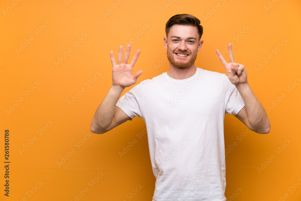 Redhead man over brown wall counting seven with fingers Redhead man over brown wall counting seven with fingers