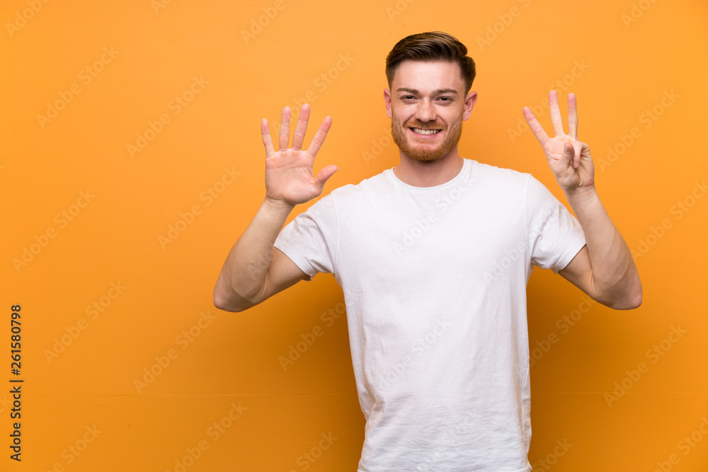 Redhead man over brown wall counting eight with fingers Redhead man over brown wall counting eight with fingers