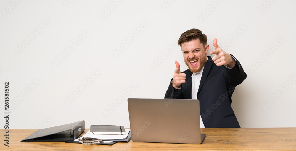 Businessman in a office pointing to the front and smiling Businessman in a office pointing to the front and smiling