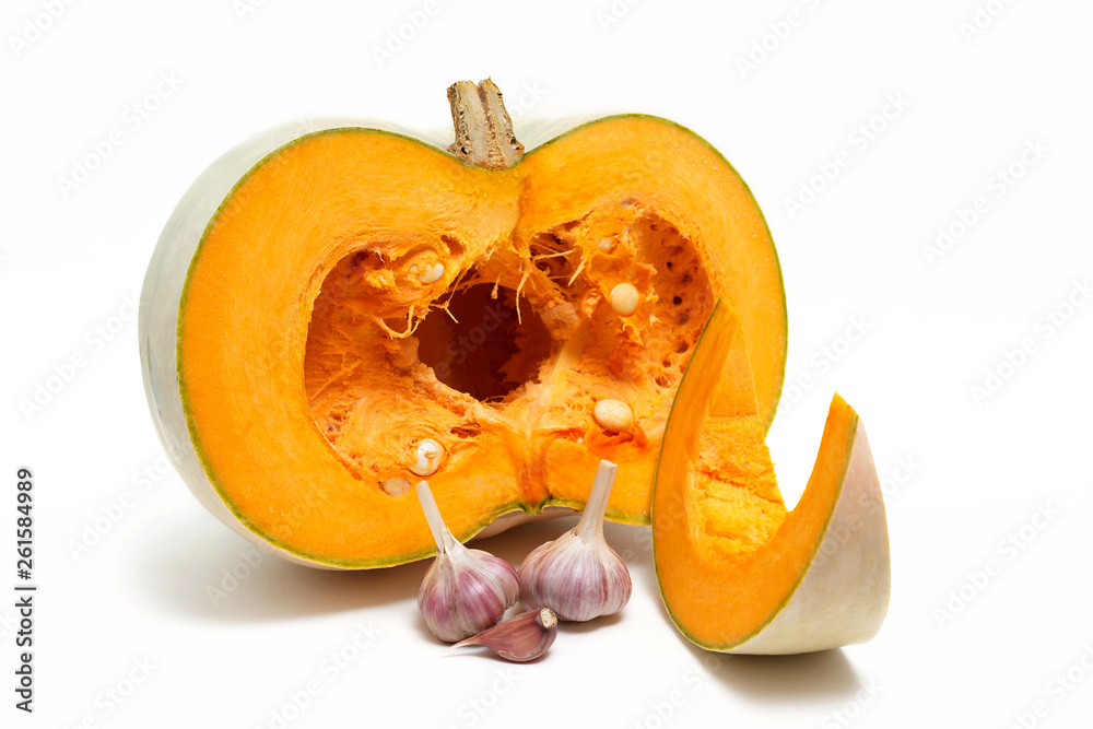 A group of one half and one slice of fresh pumpkinand garlic  isolated on a white background. Close-up.