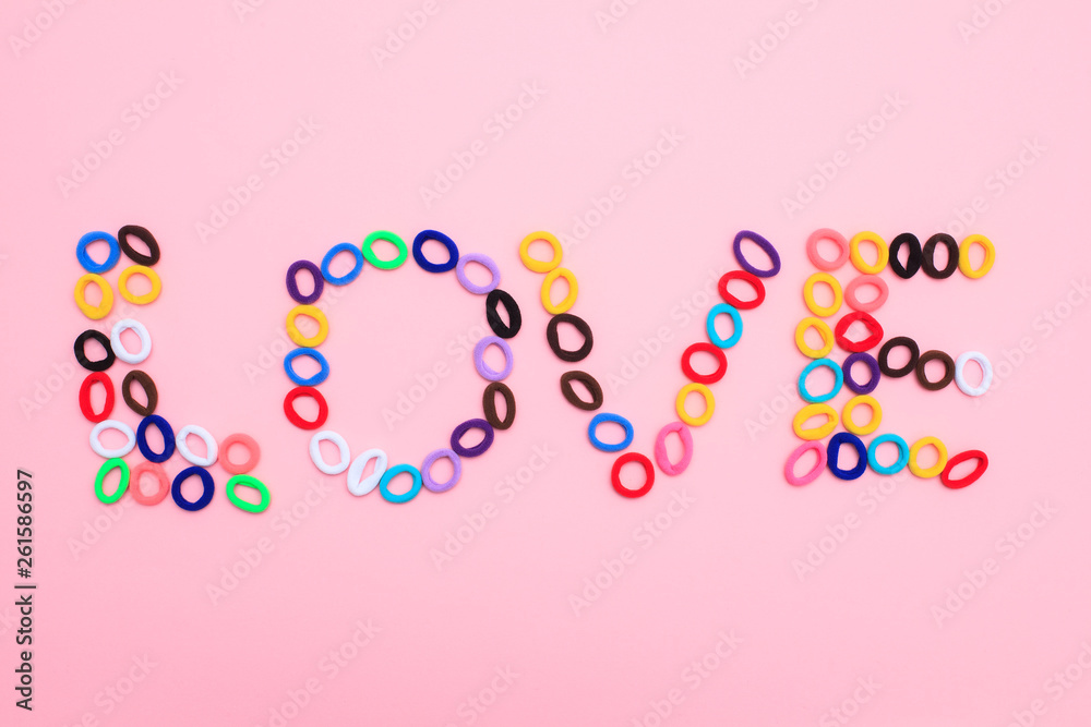 The word Love in the form of multi-colored hair elastics