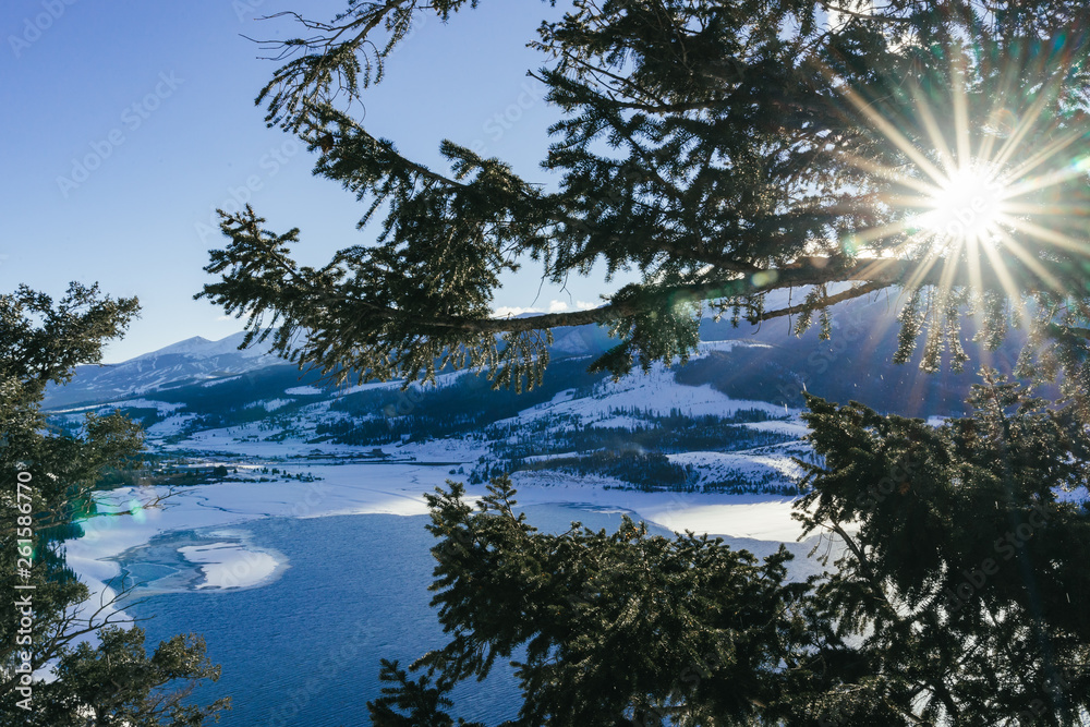 Obraz premium Snowy Mountain Scene with a Lake Water Body Near a Ski Resort at Sunset in the Beautiful Colorado Rocky Mountains