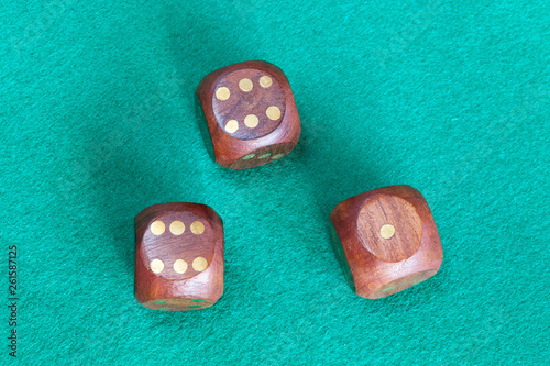 Obraz na plátně three wooden dices on green baize table