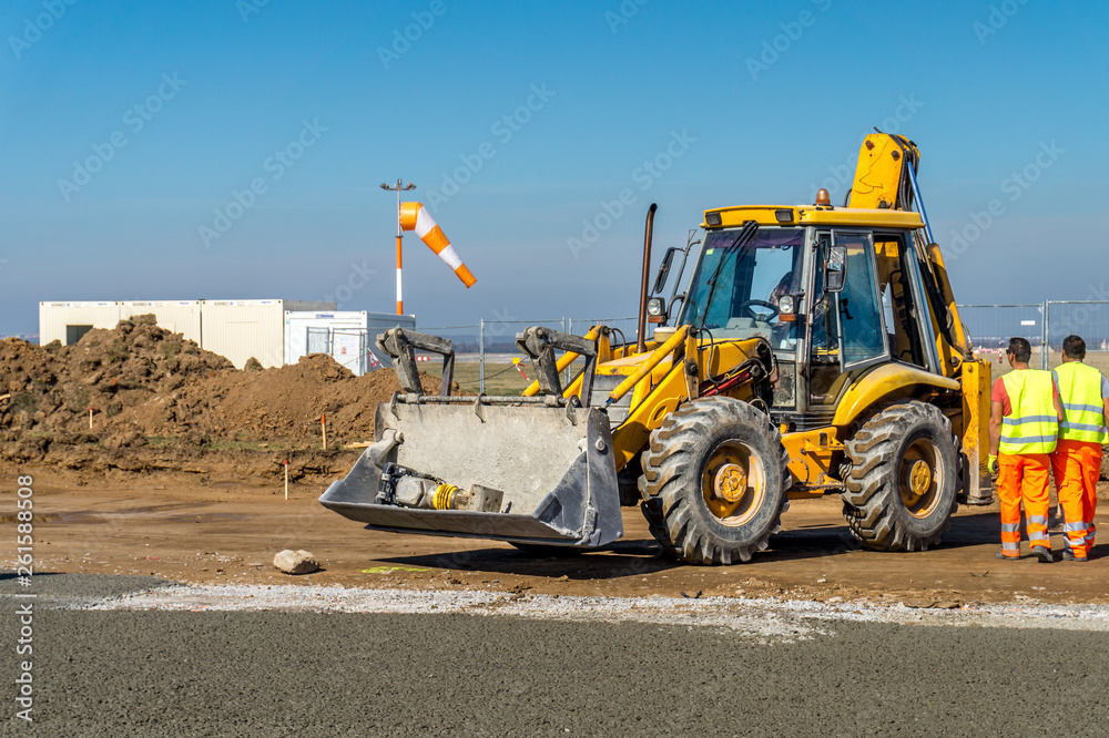 Construction site of road, building or airport with construction machinery (truck, bulldozer, excavator) and construction workers or engineers