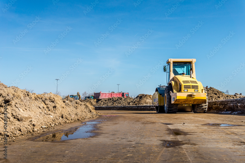 Construction site of road, building or airport with construction machinery (truck, bulldozer, excavator) and construction workers or engineers
