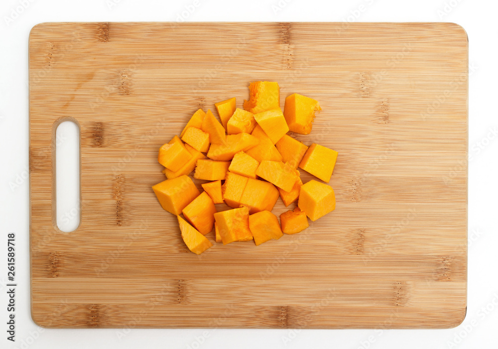 Pumpkin cut into pieces on a wooden board isolated on white background. Pumpkin cut into pieces on a wooden board isolated on white background.