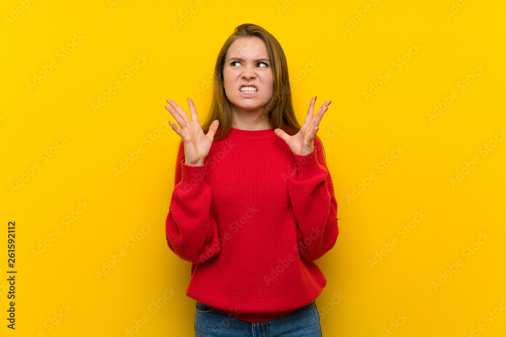 Young woman over yellow wall frustrated by a bad situation Young woman over yellow wall frustrated by a bad situation