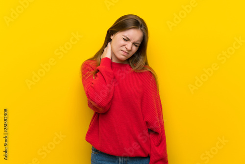 Young woman over yellow wall with neckache