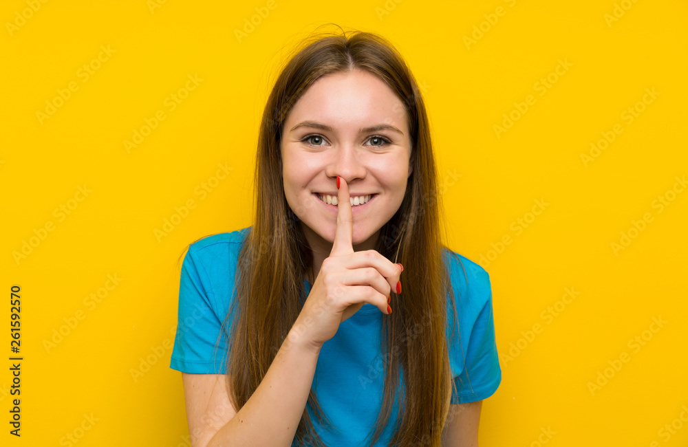 Fototapeta premium Young woman with blue shirt doing silence gesture
