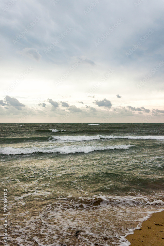 Blue and green waves with white foam on sandy beach. Black Sea, Evpatoria, Crimea, Russia. Travel, wacation concept. Text copy space.