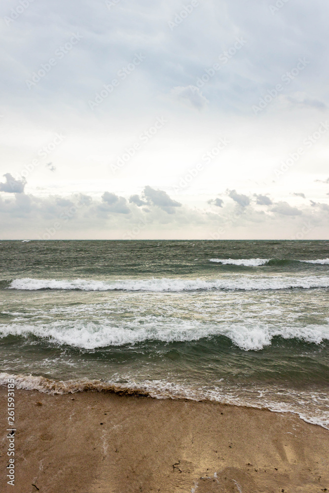 Blue and green waves with white foam on sandy beach. Black Sea, Evpatoria, Crimea, Russia. Travel, wacation concept. Text copy space. Blue and green waves with white foam on sandy beach. Black Sea, Evpatoria, Crimea, Russia. Travel, wacation concept. Text copy space.