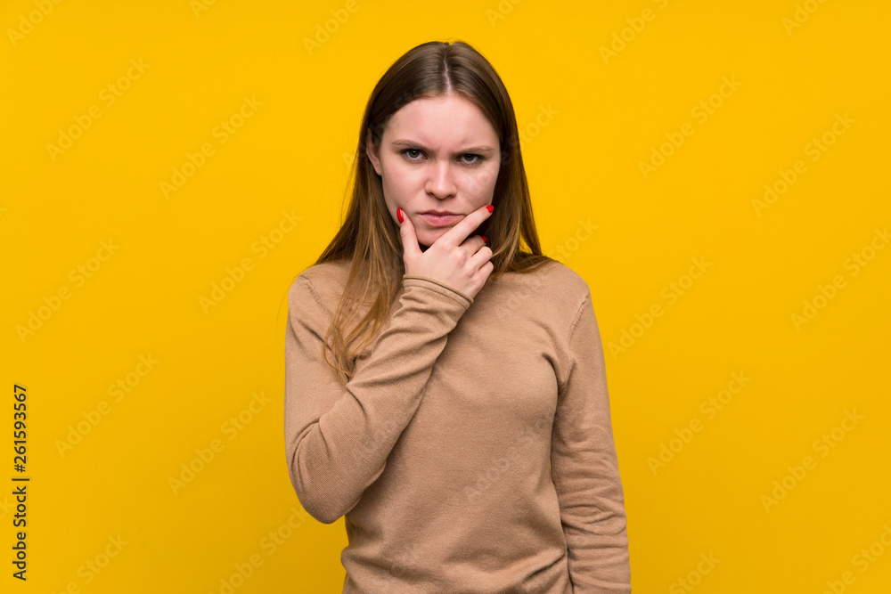 Young woman over colorful background standing and thinking an idea Young woman over colorful background standing and thinking an idea