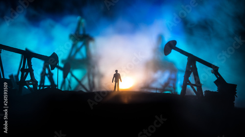 Engineering man standing against beautiful dusky sky of oil refinery plant. Silhouette of a man standing on the road at the oilfield.
