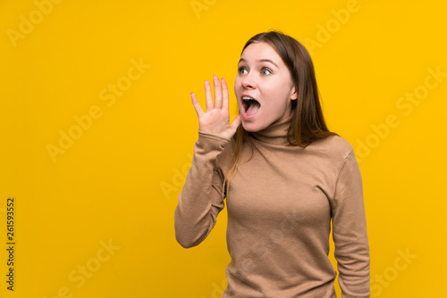 Young woman over colorful background shouting with mouth wide open