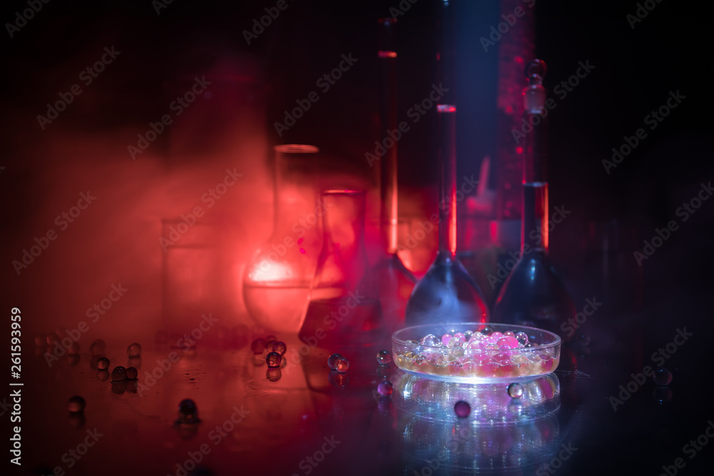 Pharmacy and chemistry theme. Test glass flask with solution in research laboratory. Science and medical background. Laboratory test tubes on dark toned background Pharmacy and chemistry theme. Test glass flask with solution in research laboratory. Science and medical background. Laboratory test tubes on dark toned background