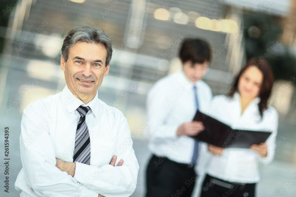 serious businessman on the background of business team. serious businessman on the background of business team.