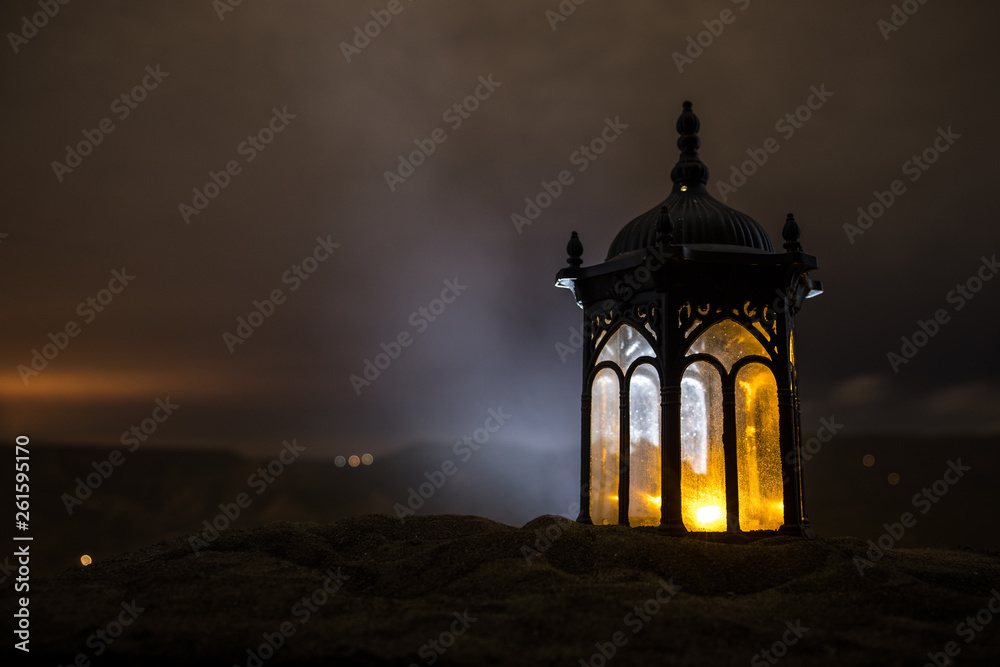 Ornamental Arabic lantern with burning candle glowing at night. Festive greeting card, invitation for Muslim holy month Ramadan Kareem. Ornamental Arabic lantern with burning candle glowing at night. Festive greeting card, invitation for Muslim holy month Ramadan Kareem.