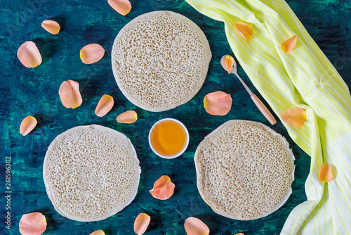 traditional Moroccan pancakes baghrir on dark green wooden background photo